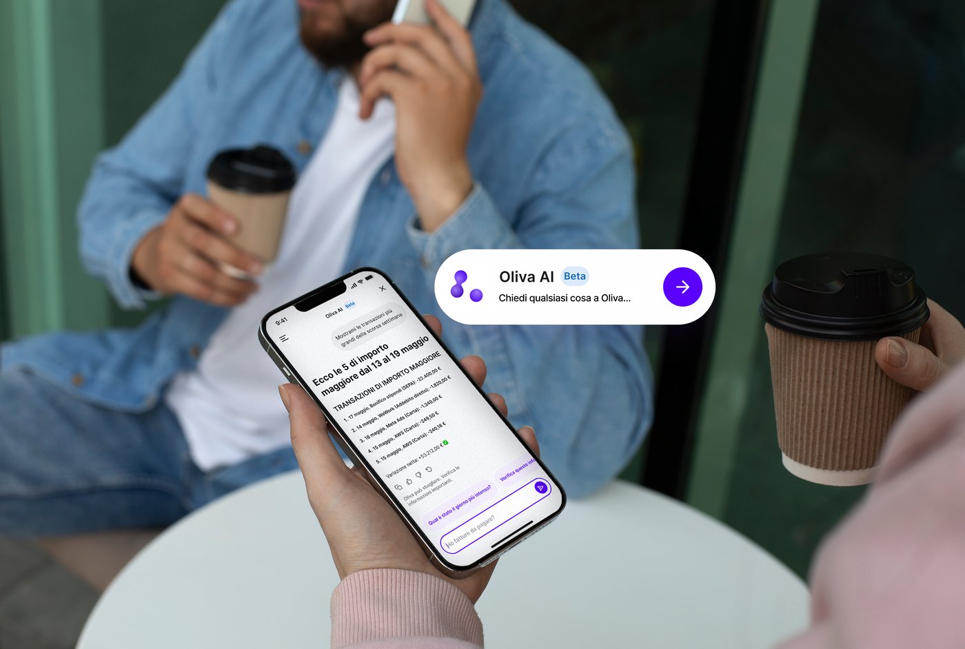 Due persone a un tavolino di un bar, una tiene in mano un telefono che mostra una chat con Oliva AI che elenca le cinque transazioni più grandi dal 13 al 19 maggio